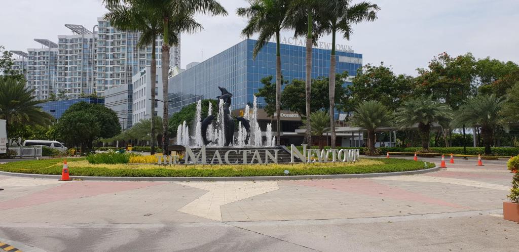 a fountain in a park in front of a building at Mactan Newtown Ocean View 360 Degree in Mactan