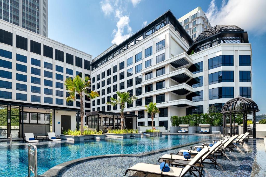 a hotel with a swimming pool in front of a building at Grand Park City Hall in Singapore