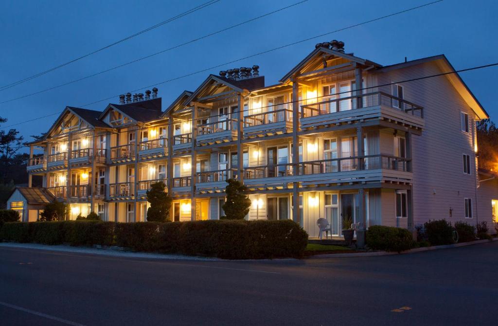 a large white building with lights on at The Wayside Inn in Cannon Beach
