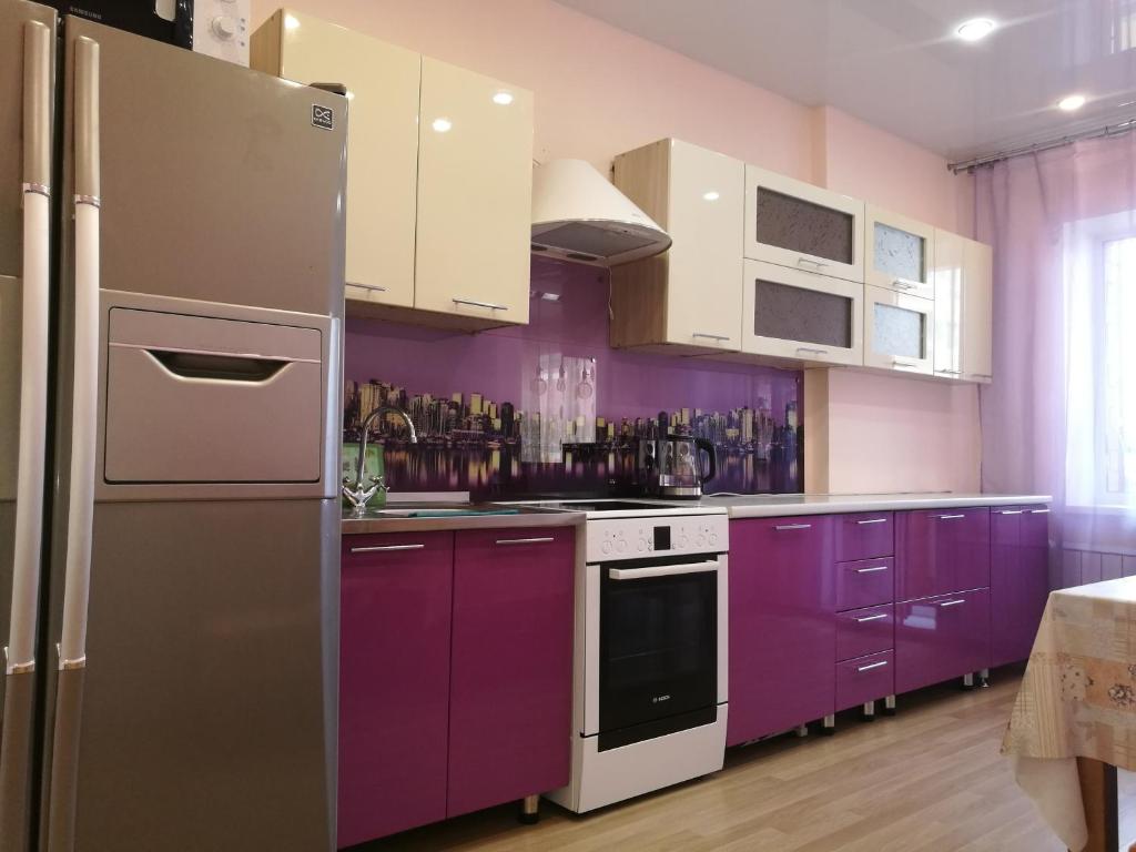 イルクーツクにあるАпартаменты на Карла Либкнехта 114のキッチン(紫色のキャビネット、冷蔵庫付)