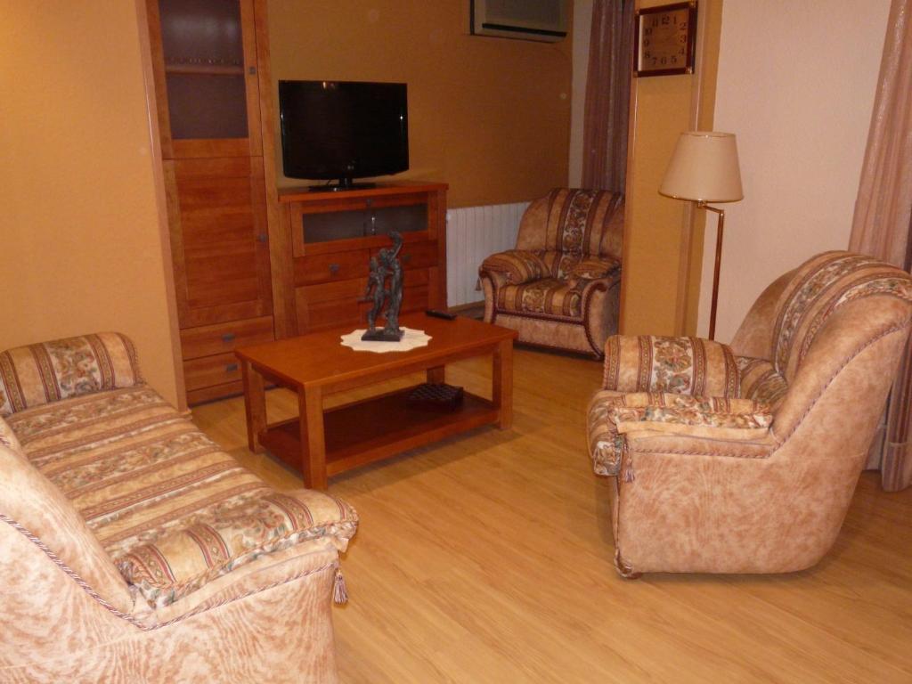 een woonkamer met 2 stoelen en een televisie bij Apartamento Turístico Guara Casa Castro in Barbastro
