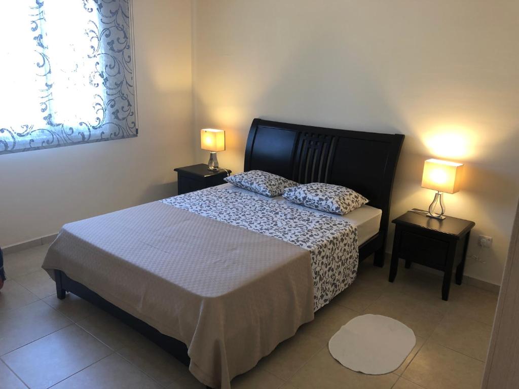 a bedroom with a bed and two lamps on tables at Tranquil Country Condo in Larnaca