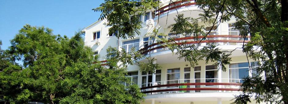 un gran edificio blanco con árboles delante de él en Prichal-Primorskiy Hotel, en Prymorskyy
