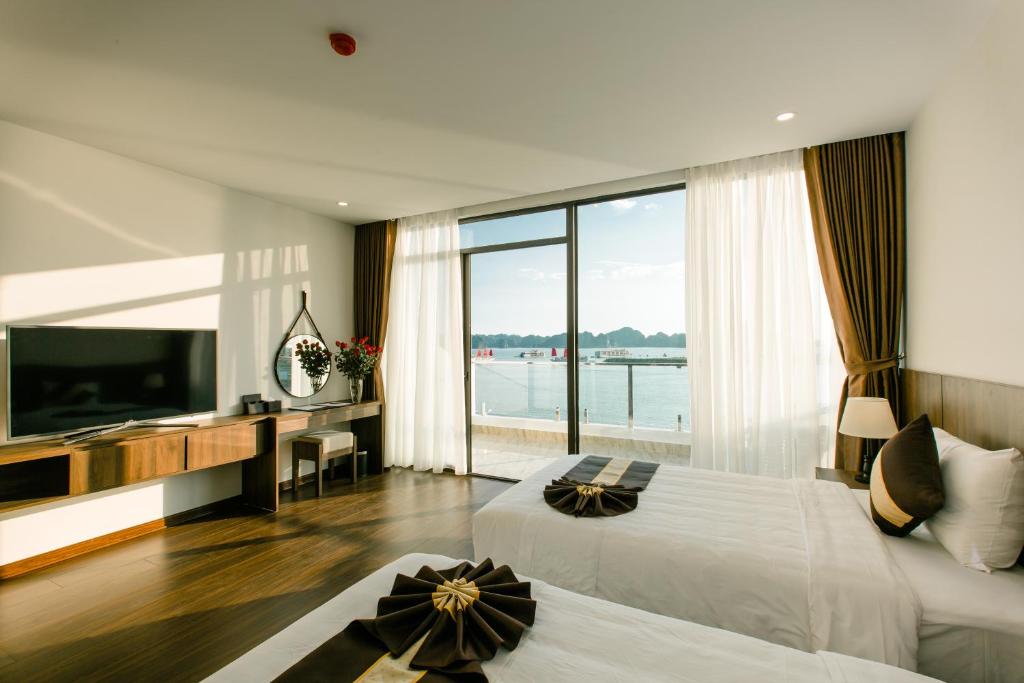 a hotel room with two beds and a large window at Sun Bay Tuan Chau Hotel in Ha Long