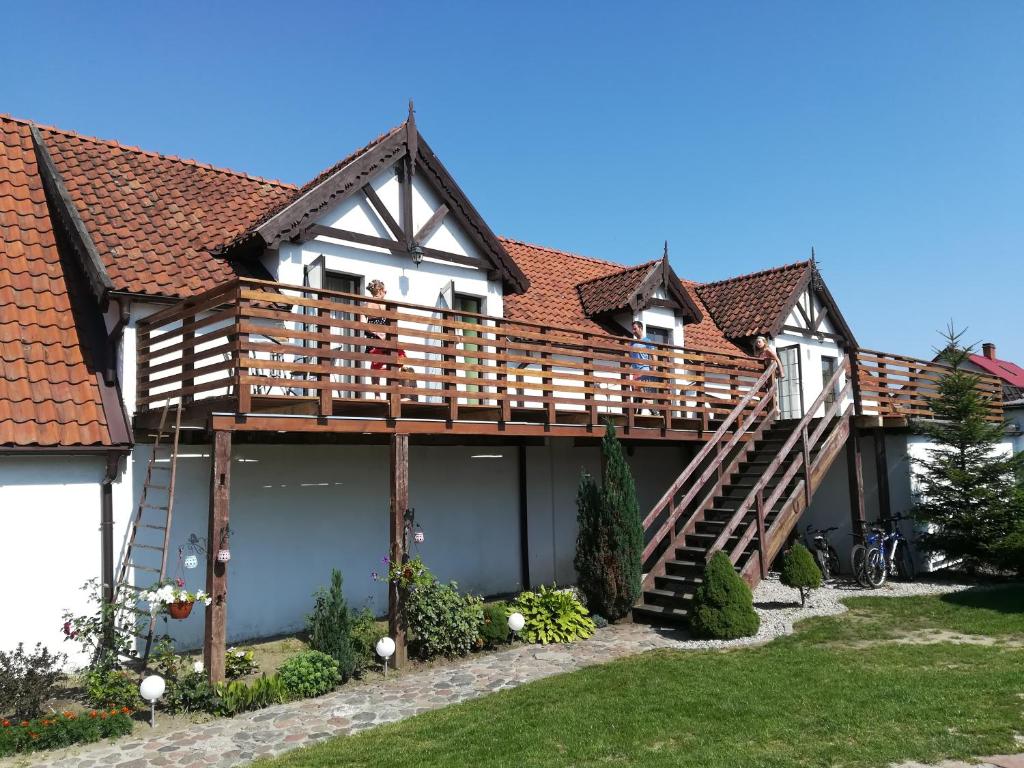 a house with a deck on top of it at Spichlerz in Rydzewo