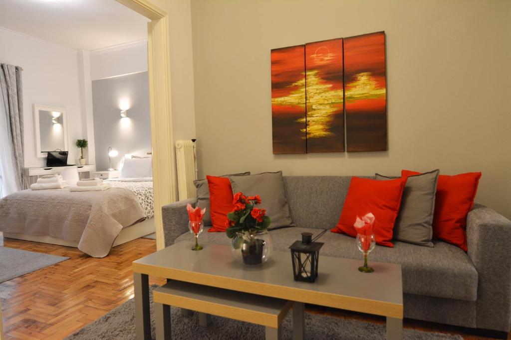 sala de estar con sofá y mesa con almohadas rojas en Stylish apartment in Kolonaki, en Atenas
