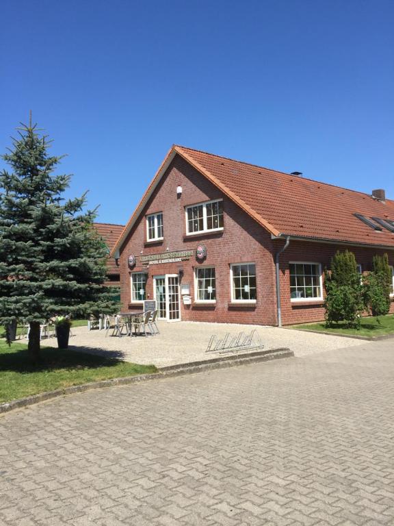 ein Backsteingebäude mit einem Baum davor in der Unterkunft Landhaus am Schaalsee in Zarrentin