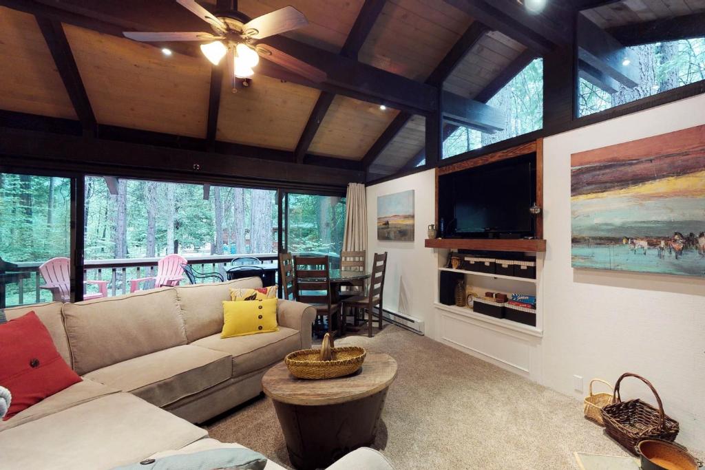 ein Wohnzimmer mit einem Sofa und einem TV in der Unterkunft Calhoun's Cabin in Camp Connell