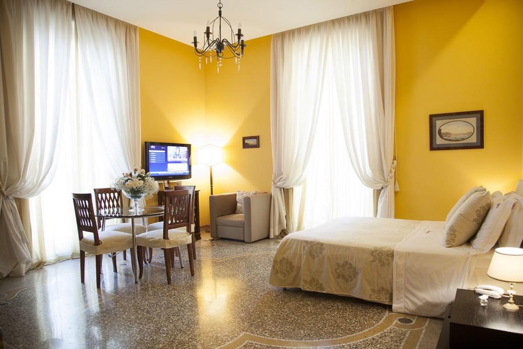Schlafzimmer mit einem Bett, einem Tisch und Stühlen in der Unterkunft B&B Orsini 46 in Neapel