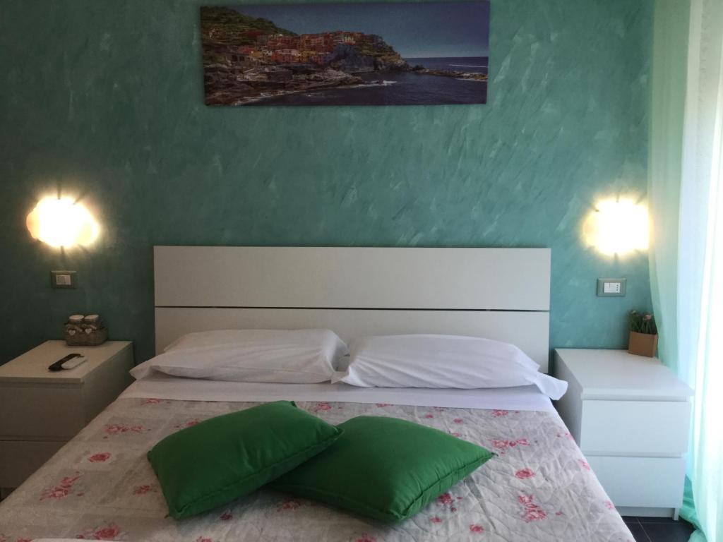 a bedroom with a large bed with two green pillows at Elite 19 in La Spezia