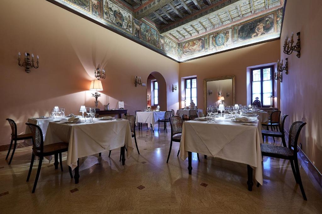 comedor con mesas y sillas y techo en Albergo Trattoria Il Leone, en Pomponesco