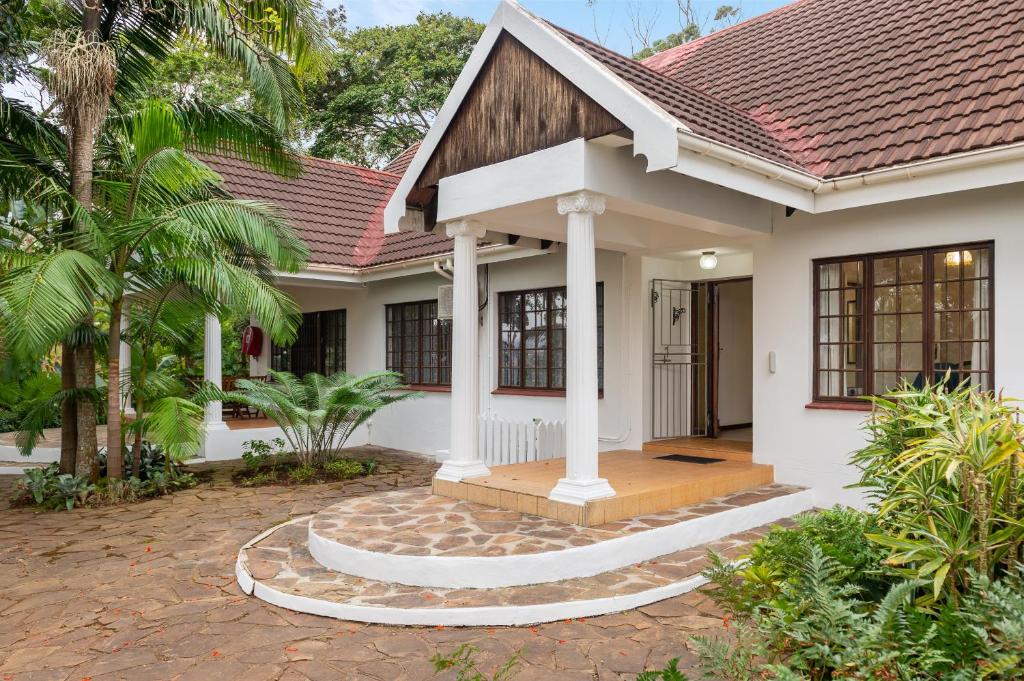 a white house with a red roof at Zesty Guesthouse in Port Edward