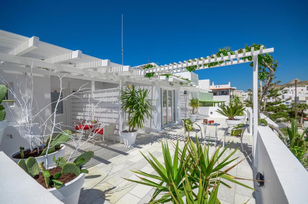 a white house with a patio with plants at Adriani Hotel in Naxos Chora