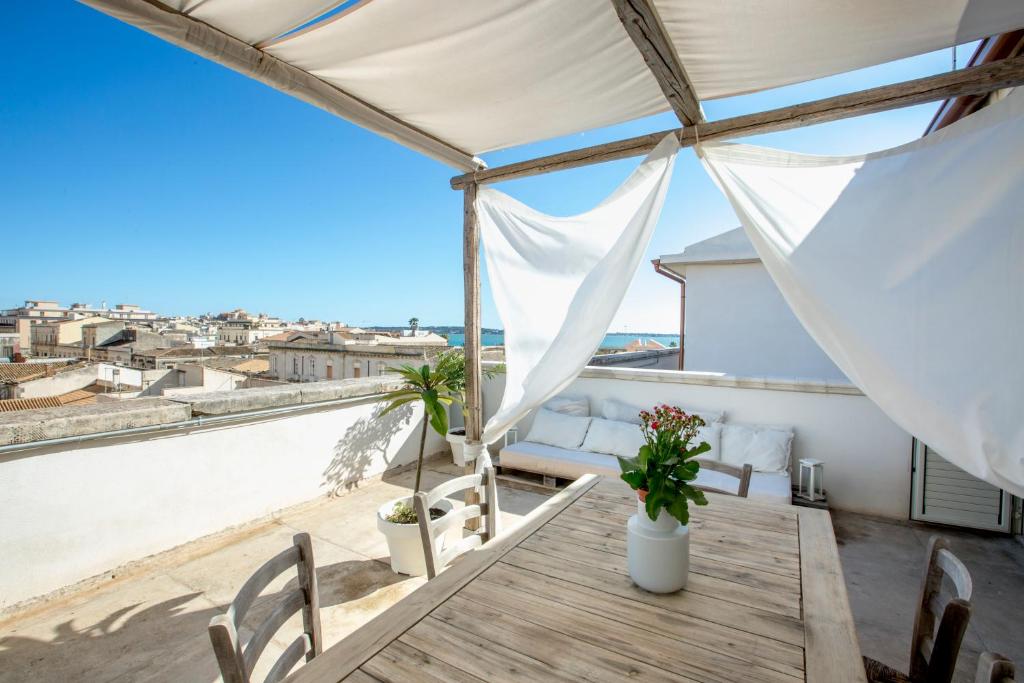 a balcony with a table and chairs and a view of the city at Ortigia Boutique Terrace apt in Syracuse