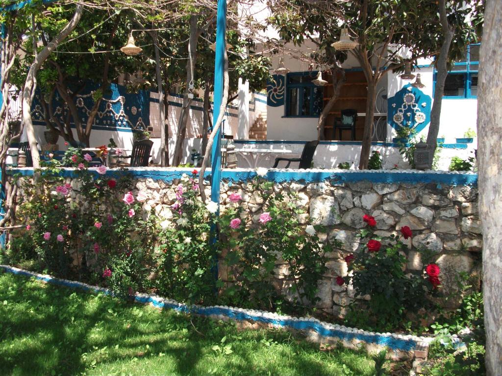 eine Steinwand mit Blumen im Hof in der Unterkunft Sardunya Otel ARKA BİNA in Kaş