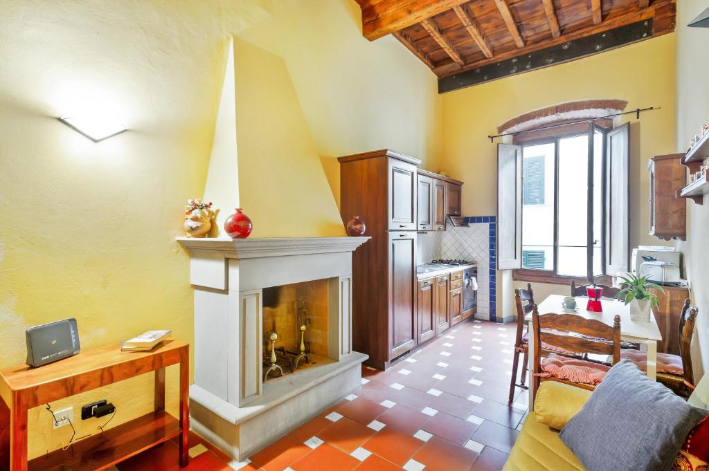Il comprend un salon avec une cheminée et une cuisine. dans l'établissement San Lorenzo Wooden Loft, à Florence