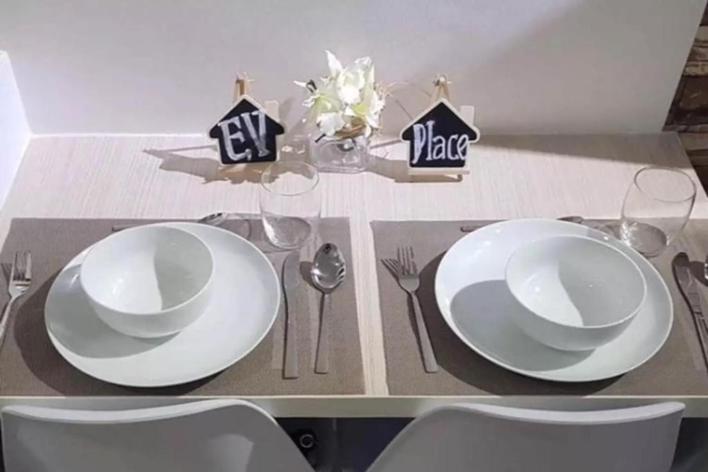 a table with two white plates and silverware on it at EV Place in Manila
