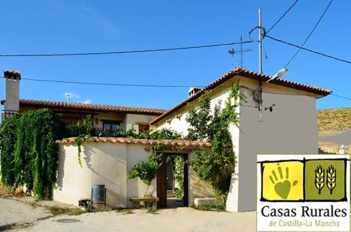 a white building with a sign in front of it at Casas rurales Santa Ana de la sierra in Santa Ana