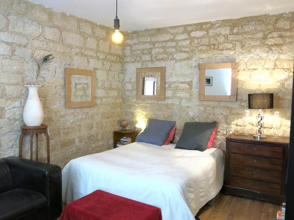 パリにあるMontmartre Del Sarte Cosy CityCosyの石壁のベッドルーム1室(ベッド1台付)