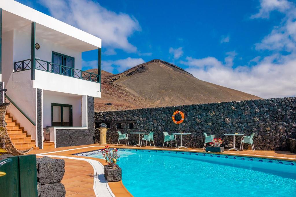 a villa with a swimming pool in front of a mountain at El Hotelito Del Golfo in El Golfo