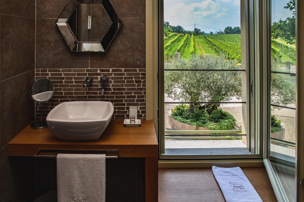 a bathroom with a sink and a window with a view at Prime Alture Wine Resort in Casteggio