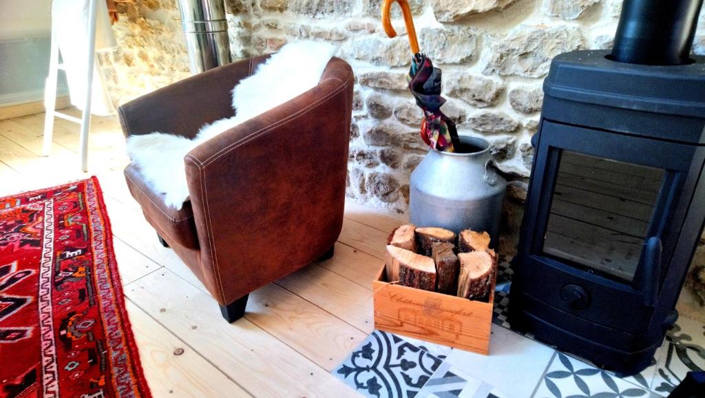 een woonkamer met een leren stoel en een houtkachel bij Les Vacances in Passy