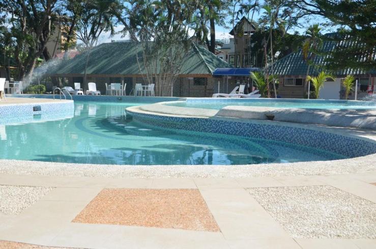 a swimming pool with a fountain in the middle at Hotel 45 Beach Resort in Bauang