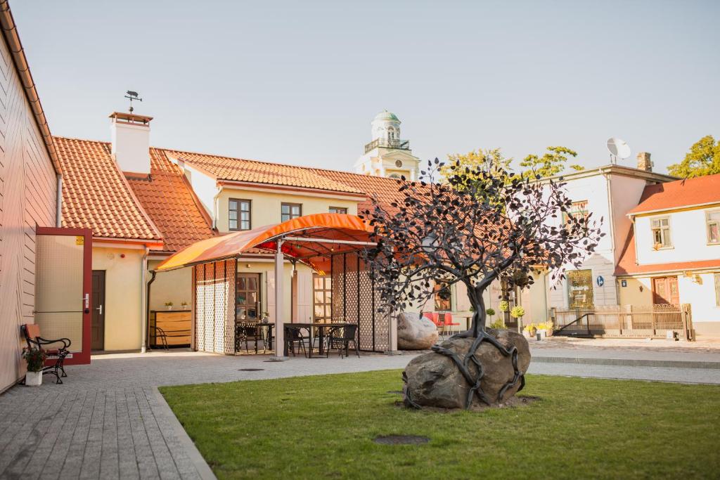 a tree sitting in the middle of a yard at Ventspils Rātslaukuma apartamenti in Ventspils