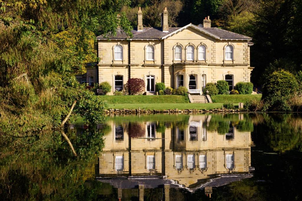 an old house with its reflection in the water at Hackness Grange Wedding Venue in Scarborough