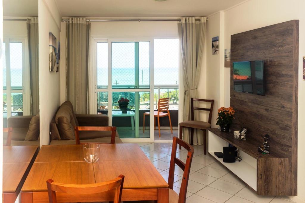 a dining room and living room with a wooden table at Lindo ! Ponta Negra Natal RN in Natal