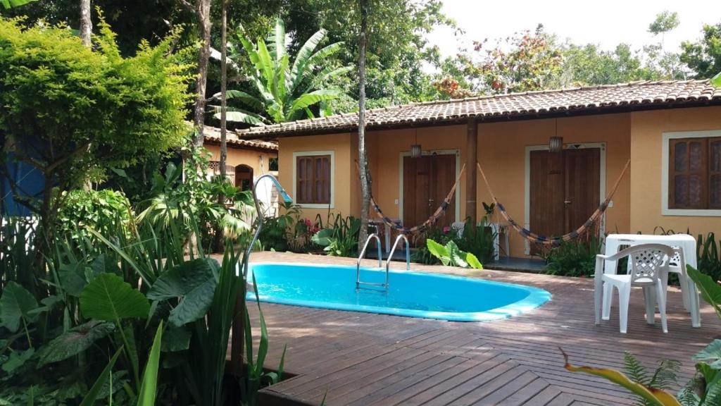 a swimming pool in the backyard of a house at Hóspedes da Terra Pousada & Chalés in Arraial d'Ajuda