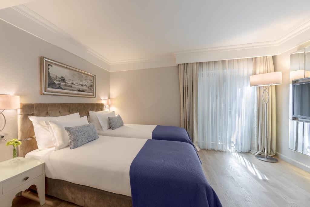 A bed or beds in a room at CVK Taksim Hotel Istanbul
