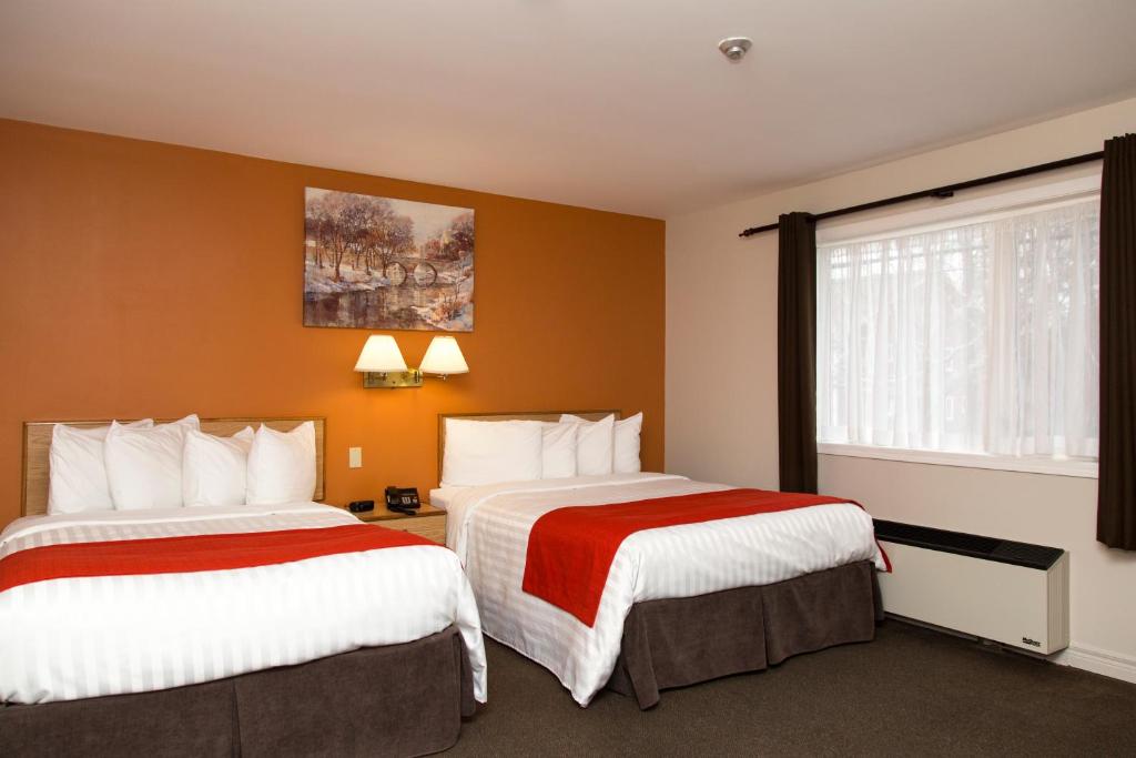 a hotel room with two beds and a window at Hotel Robin Hood in Grand Falls