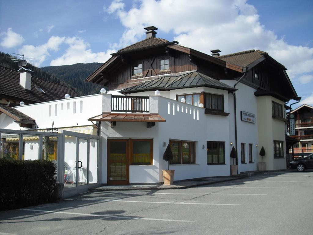 a white building with a black roof at Pizzeria Restaurant Wieser in Rasùn di Sotto