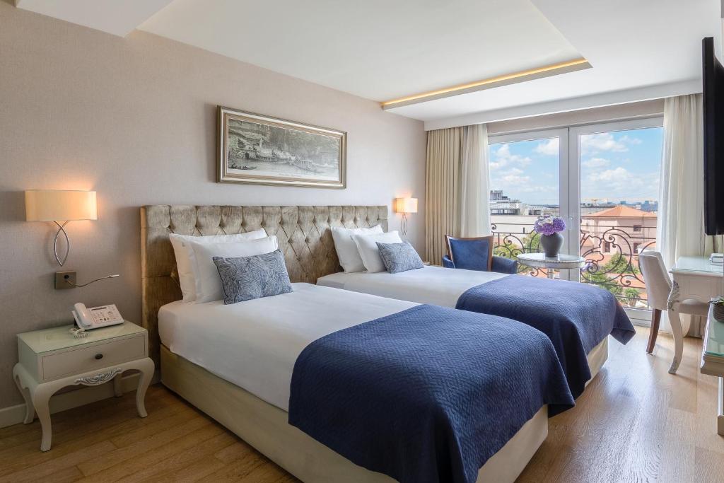 A bed or beds in a room at CVK Taksim Hotel Istanbul