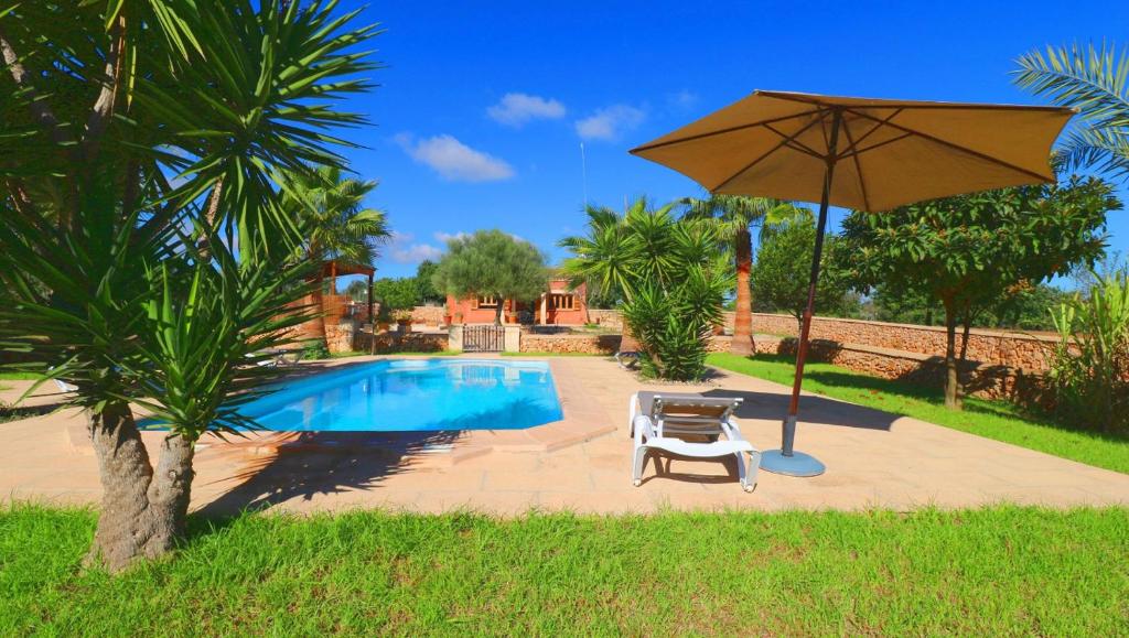 une terrasse avec un parasol, des chaises et une piscine dans l'établissement Finca Linda, à Campos