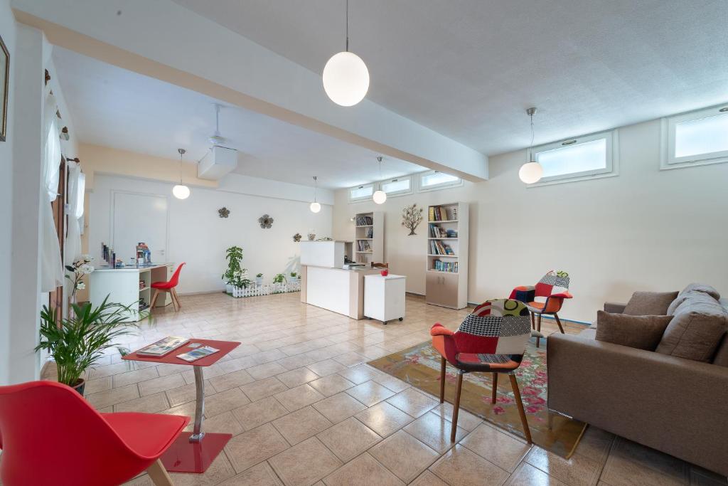 un soggiorno con sedie rosse e un divano di Byron Hotel ad Argostoli
