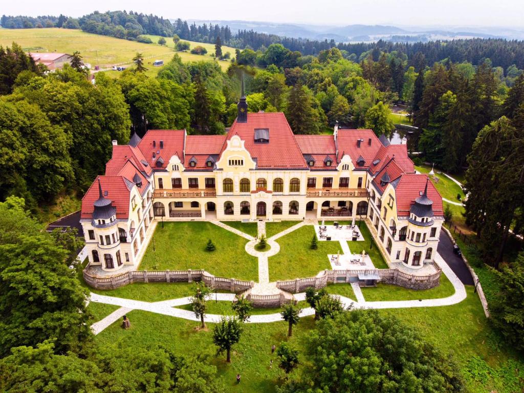 una vista aérea de una gran mansión con techo rojo en Rubezahl-Marienbad Luxury Historical Castle Hotel & Golf-Castle Hotel Collection, en Mariánské Lázně