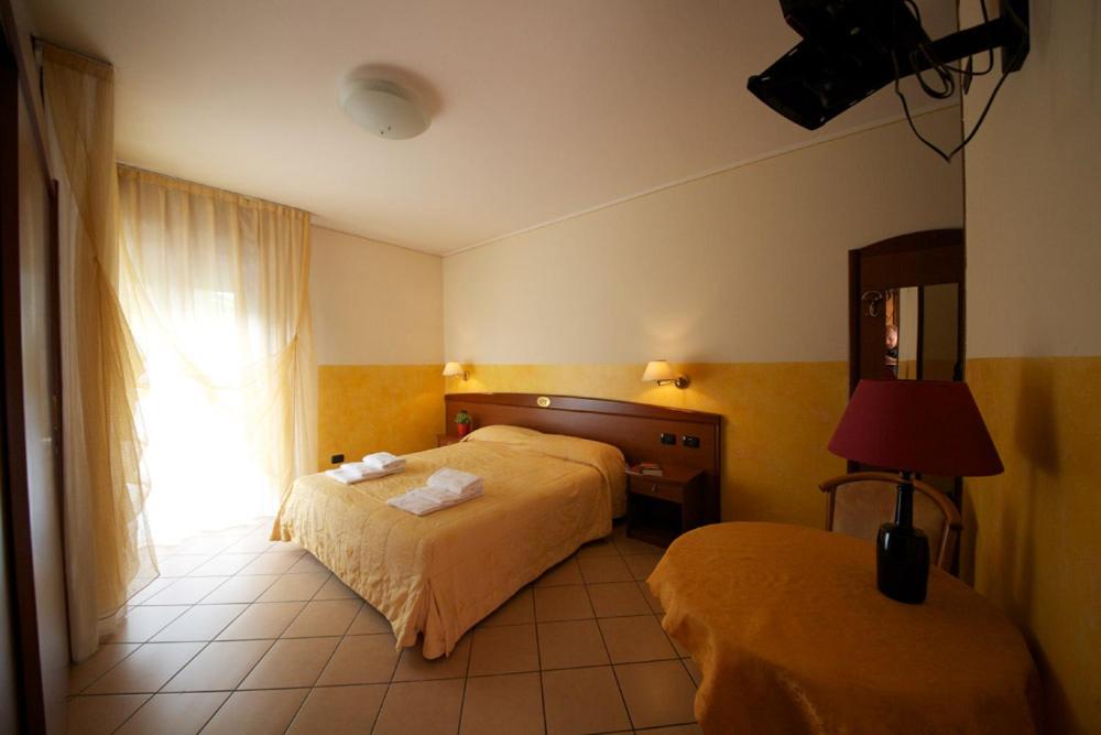 ヴェローナにあるVilla Terriのベッド2台と窓が備わるホテルルームです。