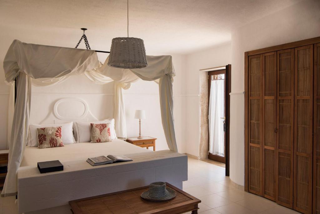 a bedroom with a white bed with a canopy at La Peschiera in Monopoli