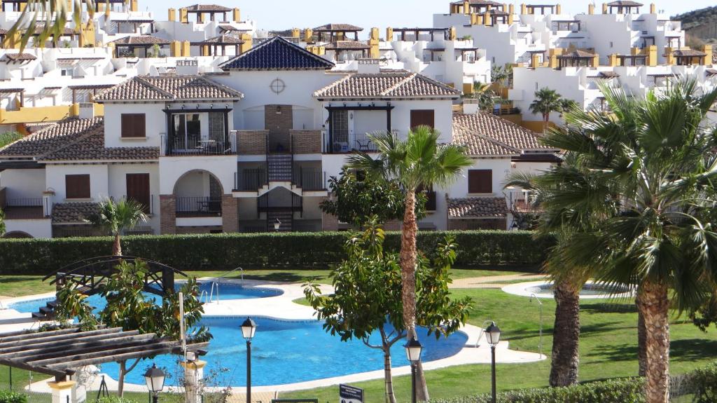 uma vista para um edifício com palmeiras e uma piscina em Al-Andalus Thalassa em Vera