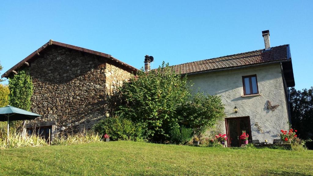a large stone house on a green lawn at Cottage in Auvergne in Laval-sur-Doulon