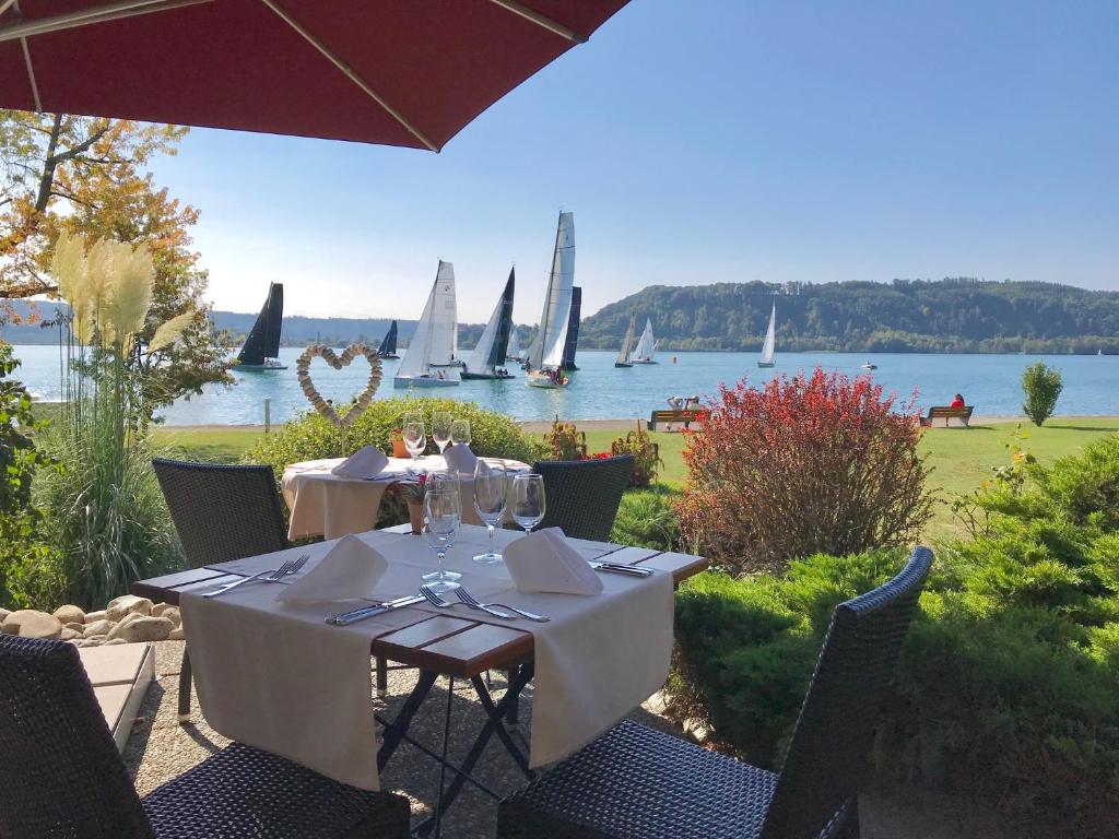 a table with wine glasses and a view of the water at Hotel Jean-Jacques Rousseau in La Neuveville