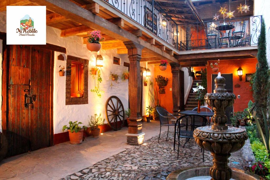 een patio met een fontein en een tafel en stoelen bij Hotel Mi Pueblito by Rotamundos in Tapalpa