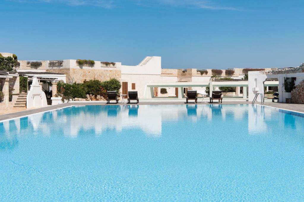 a large swimming pool with chairs in a building at La Peschiera in Monopoli