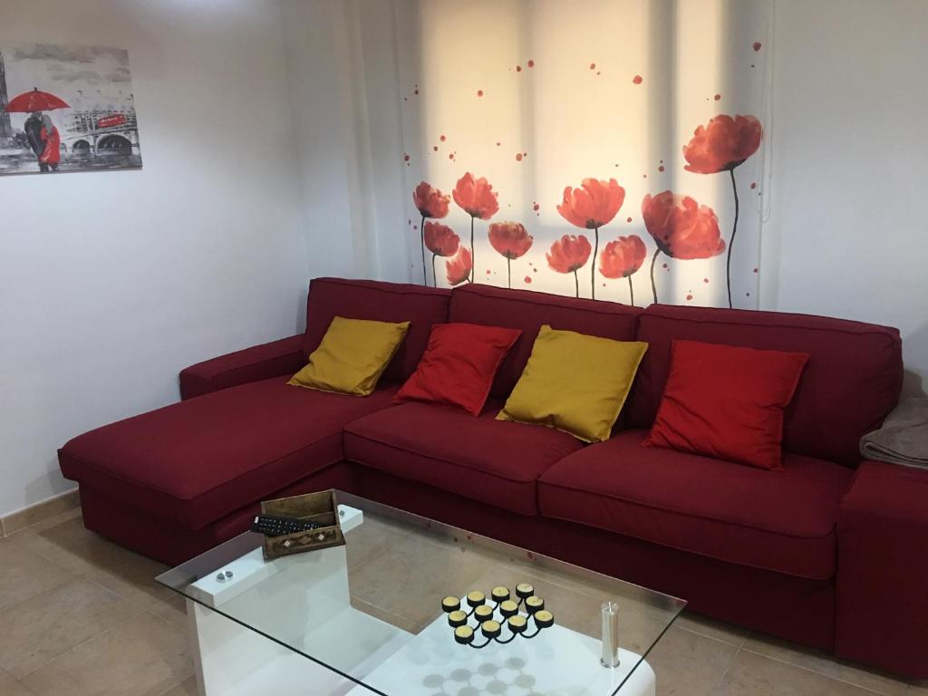 een woonkamer met een bank met rode en gele kussens bij Apartamento Infantes in Ronda