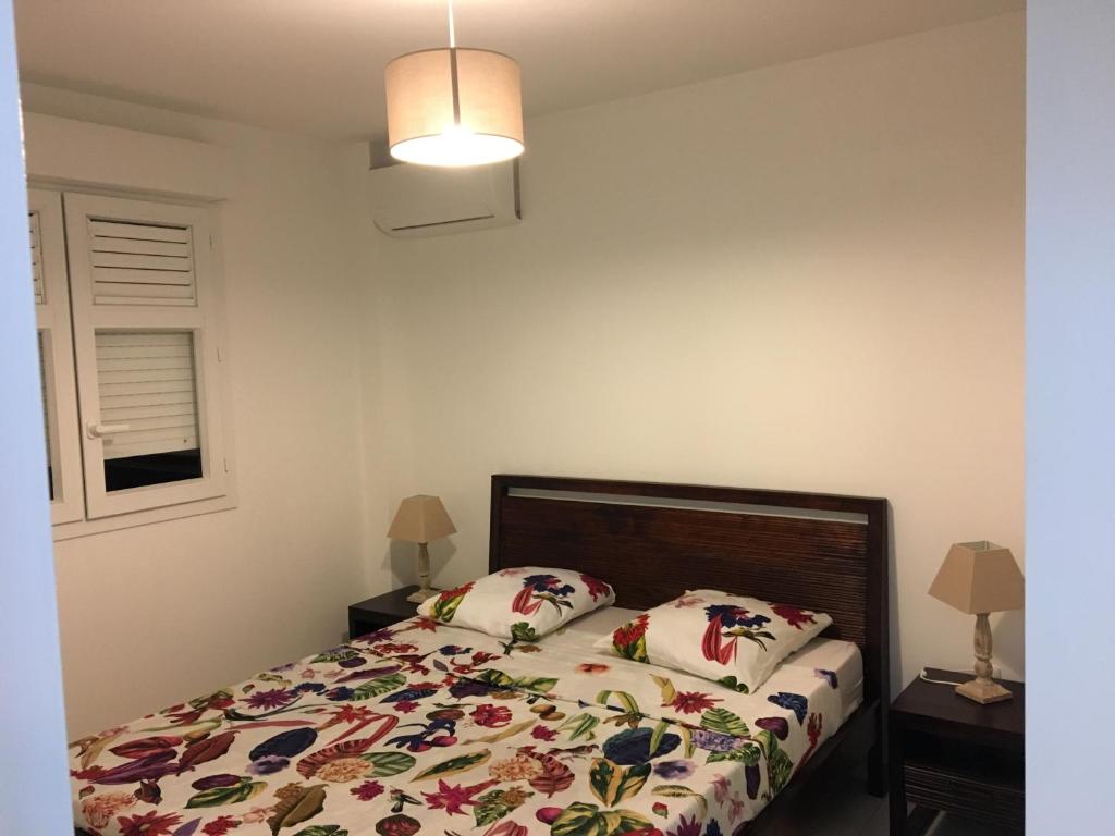 a bedroom with a bed with two pillows on it at 3 Rue du Bois d’inde Anse-Mitan in Les Trois-Îlets