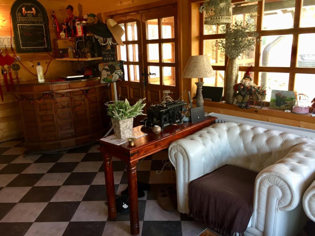 a living room with two white chairs and a table at Brvnare Mrkic in Kremna