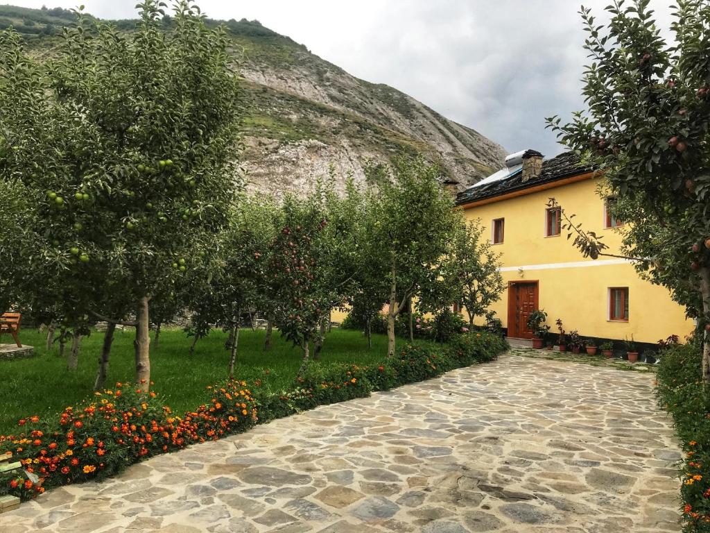 una casa y un jardín con árboles y flores en Guest House Sabriu, en Rabdisht