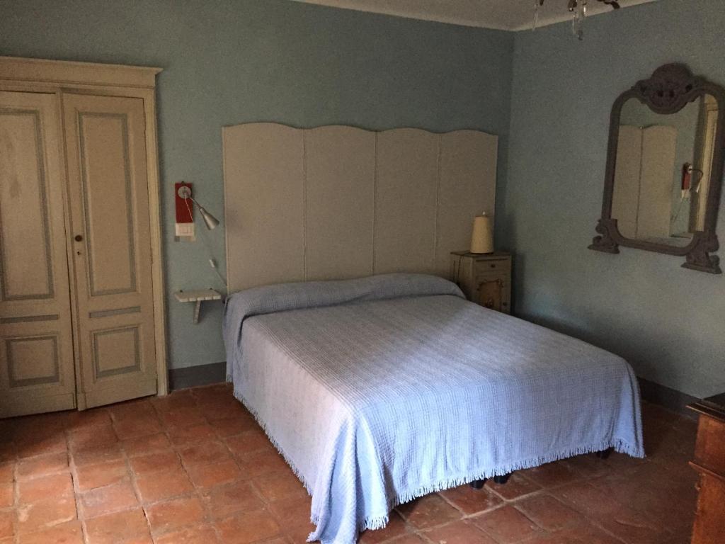 Schlafzimmer mit einem Bett und einem Wandspiegel in der Unterkunft Appartamenti a Magnano in Magnano
